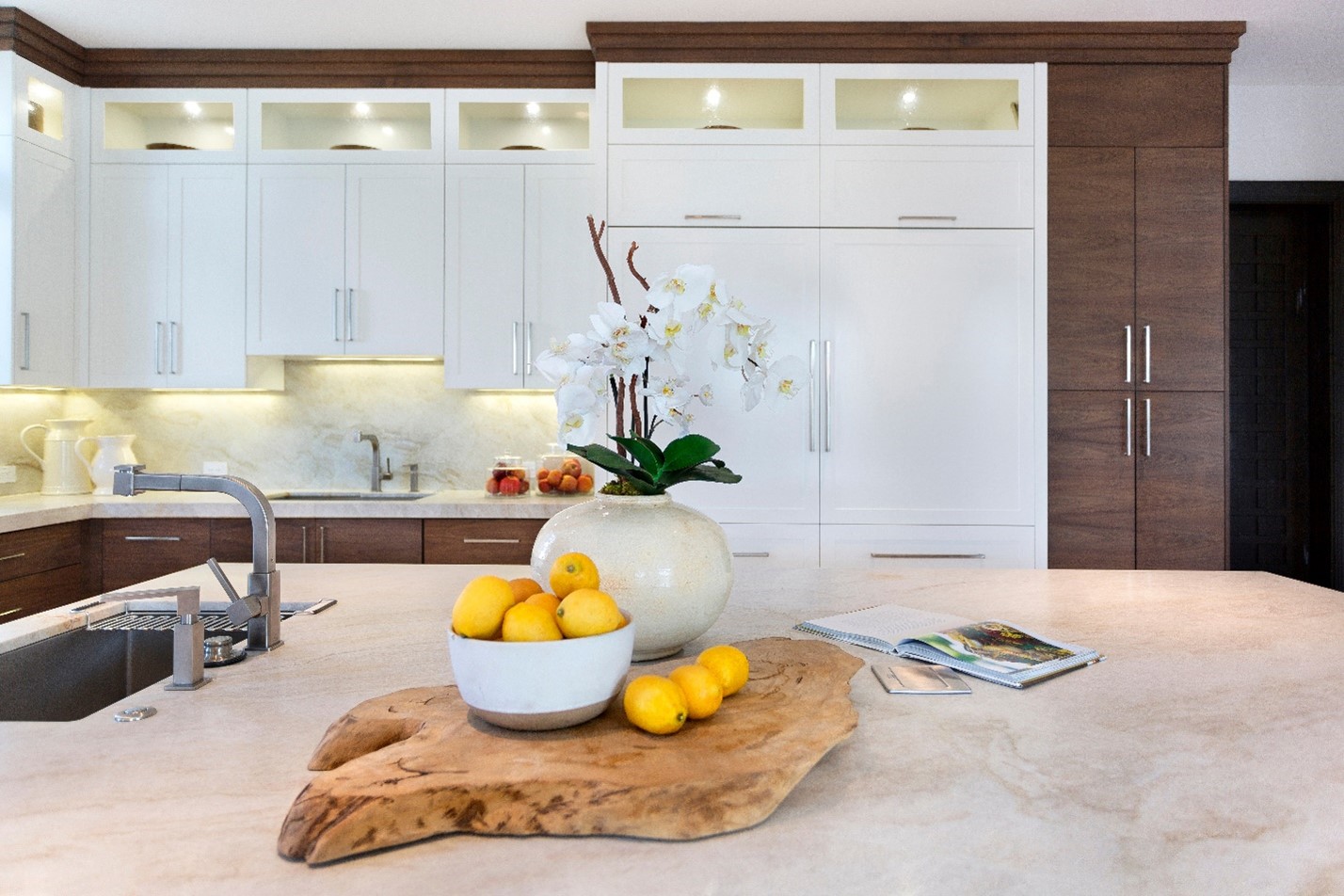 a staged kitchen in a home for sale with lemons and orchids on display